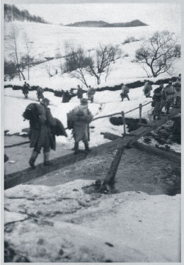 Austro-Hungarian soldiers walking over wooden bridge in winter