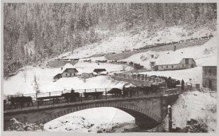 Austro-Hungarian soldiers hauling wagons over an Italian bridge in winter