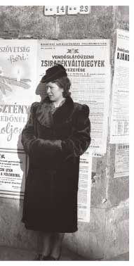 Hungarian woman in fur coat flanked by anti-Semitic propaganda
