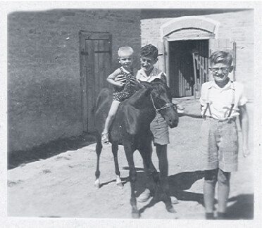 Gyula with cousin Géza with little Miklós in the Fábos family courtyard in 1944