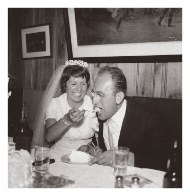Edith Haüsermann Fabos laughs while feeding cake to Gyula Fábos on their wedding day in 1959