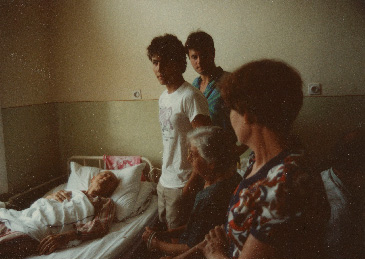 Pista lies in a hospital bed with Leukemia while Laci, Adrian, and Ari stand by in 1983