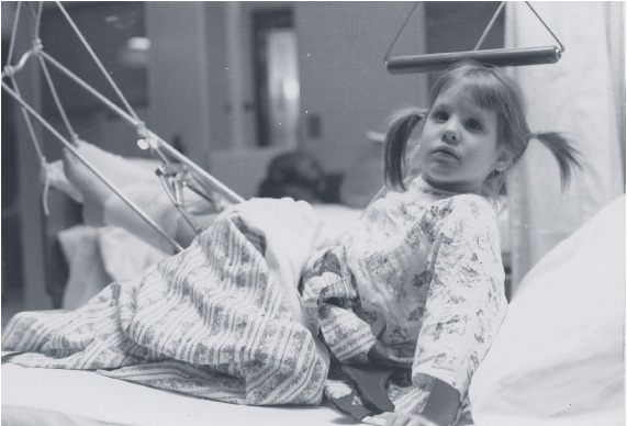 Bettina props herself up in a hospital bed after being hit by a car in 1970 at age 5