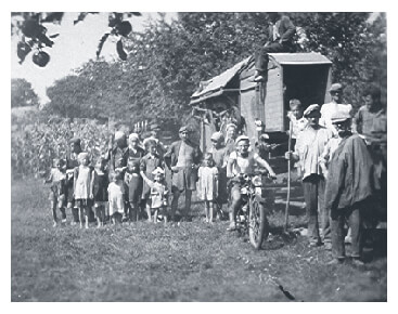 Fábos family threshing machine operation with Gyula Fábos leading on a motorcycle