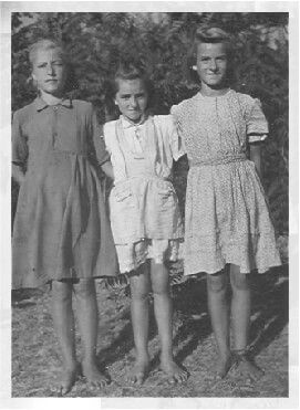 Three young and barefoot farm girls posing for the camera on the Fábos farm in rural Hungary in 1940