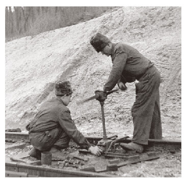 Two workers repairing a train track in 1950s Hungary
