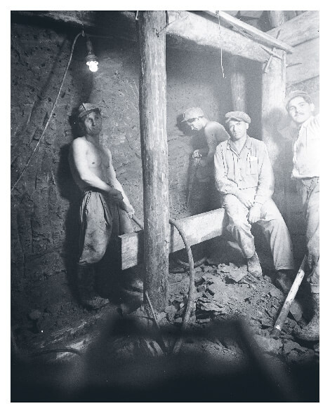 A light dangles in a mine as workers take a moment's rest underground