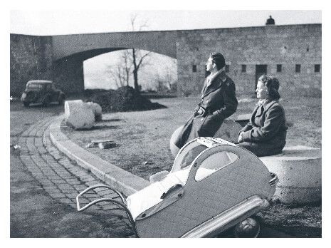 Parents sitting separately with baby carriage in 1955 Hungary