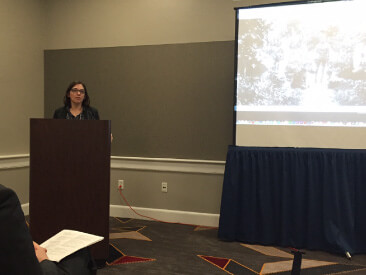 Leslie speaking at a podium.