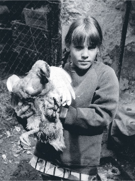 Bettina holds a chicken.